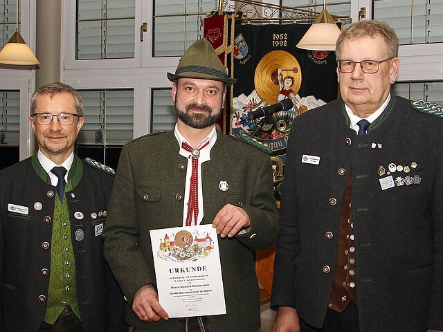Hohe Auszeichnungen für 10 jährige Tätigkeit als 1. Schützenmeister.
(v.l.) 1. Gauschützenmeister Markus Mayr, Richard Zinsmeister jun. (Auerhahn Kunding) und 2. Gauschützenmeister Peter Kiowski.