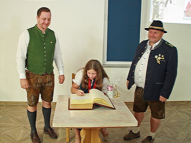 Eintragung in das Goldene Buch der Gemeinde
(v.l.) 2. Bürgermeister Marco Stemmer, Emilia Fürhofer und 1. Schützenmeister Roland Nowak.